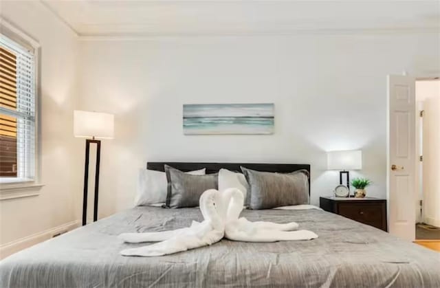 bedroom with baseboards and crown molding