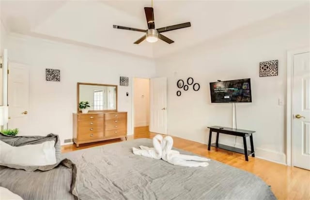 bedroom featuring ceiling fan, baseboards, and wood finished floors