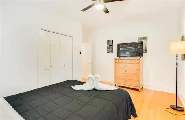 bedroom featuring a closet, wood finished floors, and a ceiling fan