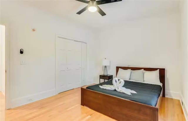 bedroom with ceiling fan, a closet, and wood finished floors