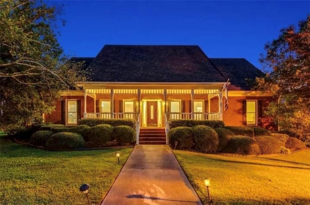 view of front of house featuring covered porch and a front lawn