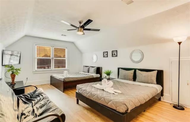 bedroom with lofted ceiling, light wood finished floors, ceiling fan, and visible vents