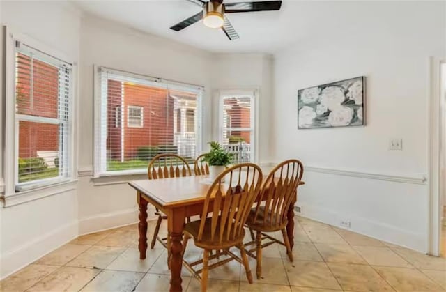 dining area with light tile patterned flooring, a ceiling fan, and baseboards