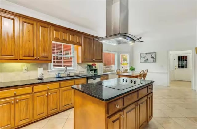 kitchen with island exhaust hood, black electric stovetop, brown cabinetry, a kitchen island, and a sink