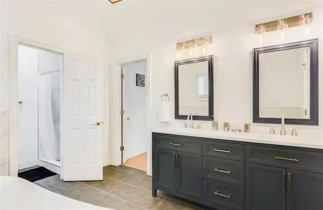 full bath featuring double vanity, a shower, a sink, and tile patterned floors