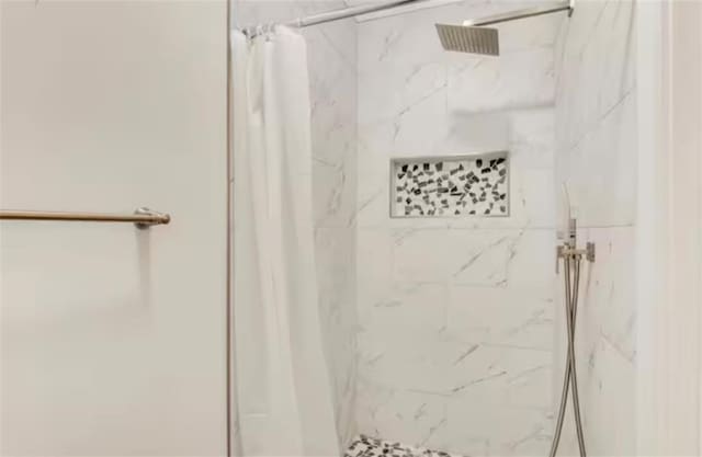 bathroom featuring a marble finish shower