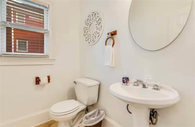 bathroom featuring toilet and baseboards