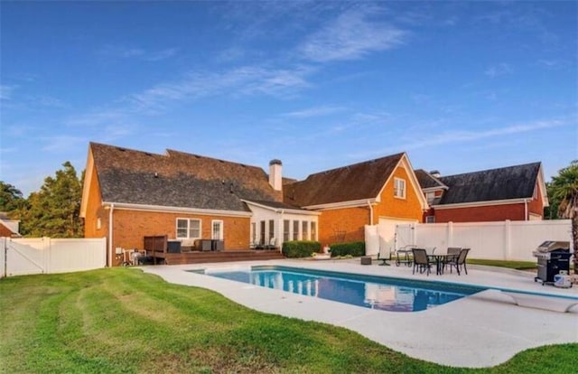 rear view of property featuring a fenced backyard, a fenced in pool, a lawn, and a patio