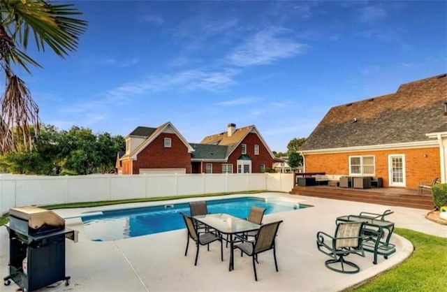 view of swimming pool with a fenced backyard, a patio area, a grill, and a fenced in pool