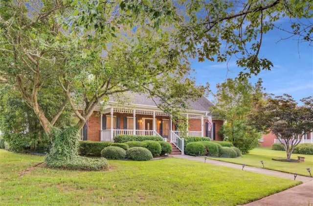 view of front of property featuring covered porch and a front yard