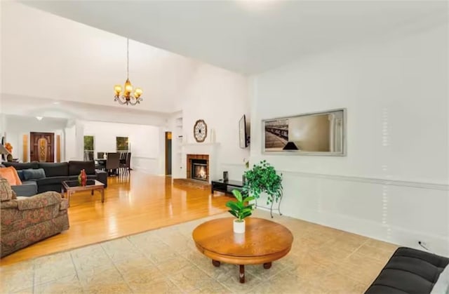 living area with a warm lit fireplace and an inviting chandelier