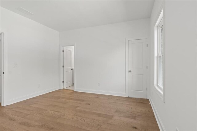 unfurnished bedroom featuring light wood-type flooring and baseboards