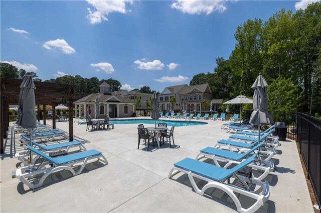 community pool with fence and a patio area