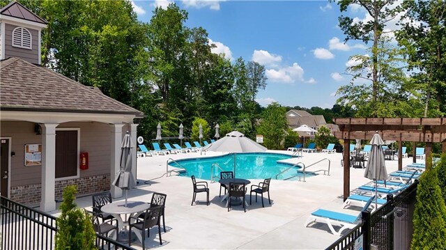 pool with a patio and fence