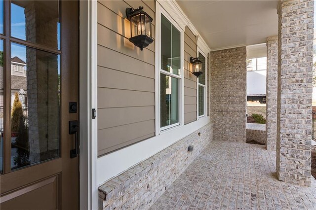 details featuring white cabinets, stainless steel microwave, and light stone counters