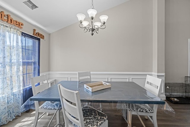 dining area featuring lofted ceiling, dark hardwood / wood-style floors, and a chandelier