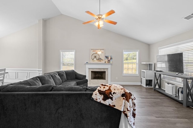 living room featuring hardwood / wood-style flooring, vaulted ceiling, ceiling fan, and a high end fireplace