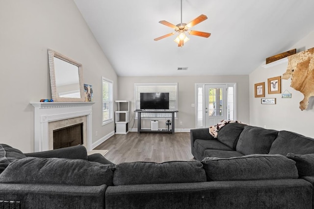 living room with ceiling fan, a healthy amount of sunlight, a fireplace, and light hardwood / wood-style flooring