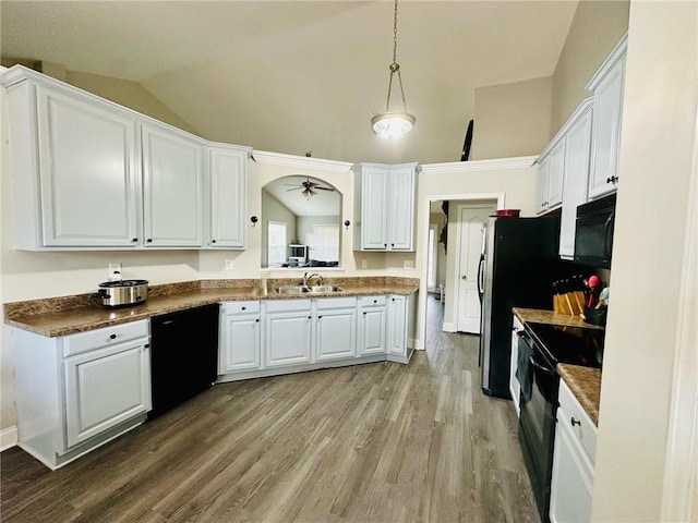 kitchen featuring pendant lighting, sink, lofted ceiling, white cabinetry, and black appliances