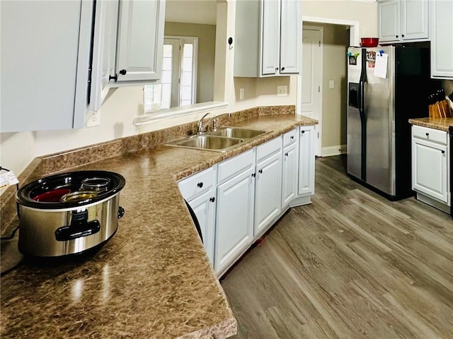 kitchen featuring white cabinetry, sink, hardwood / wood-style flooring, and stainless steel fridge