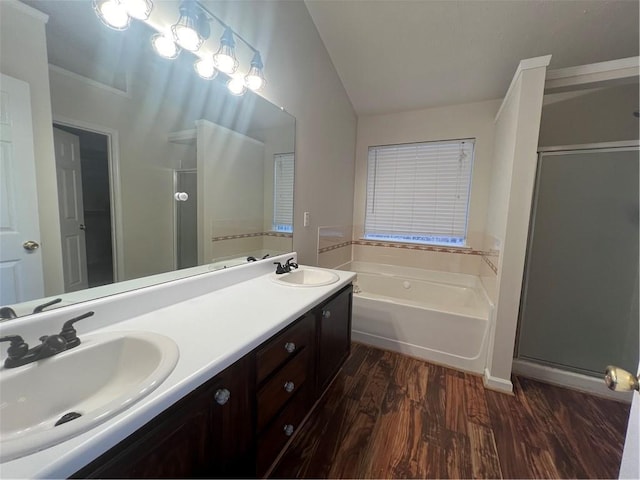 bathroom featuring vanity, hardwood / wood-style flooring, vaulted ceiling, and separate shower and tub