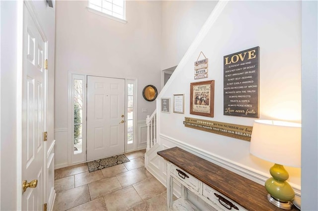 foyer with a high ceiling and light tile patterned floors