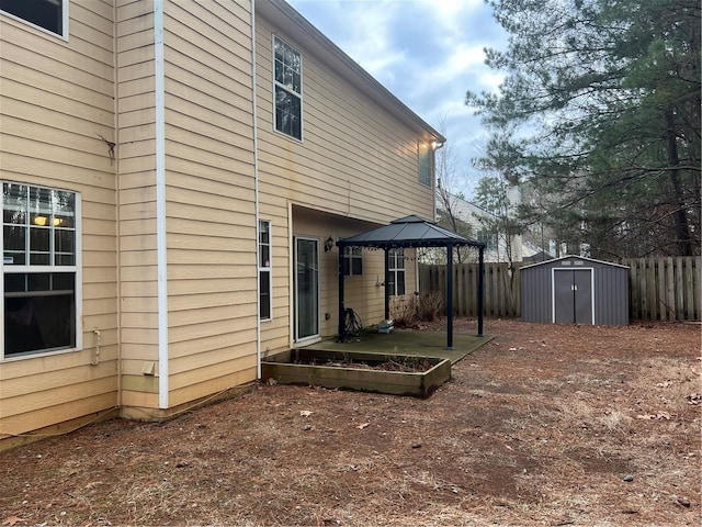 back of house featuring a gazebo and a storage unit