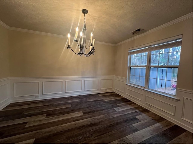 unfurnished dining area with an inviting chandelier, ornamental molding, dark hardwood / wood-style flooring, and a textured ceiling