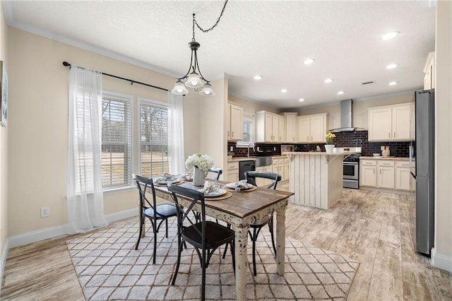 dining space with light wood-style flooring, a textured ceiling, recessed lighting, crown molding, and baseboards