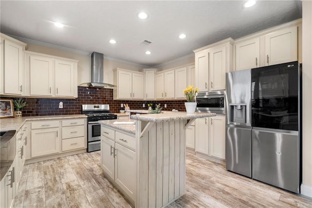 kitchen featuring light wood-style flooring, wall chimney exhaust hood, visible vents, and stainless steel appliances