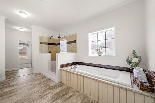 full bath featuring a garden tub, wood finished floors, baseboards, a walk in shower, and crown molding