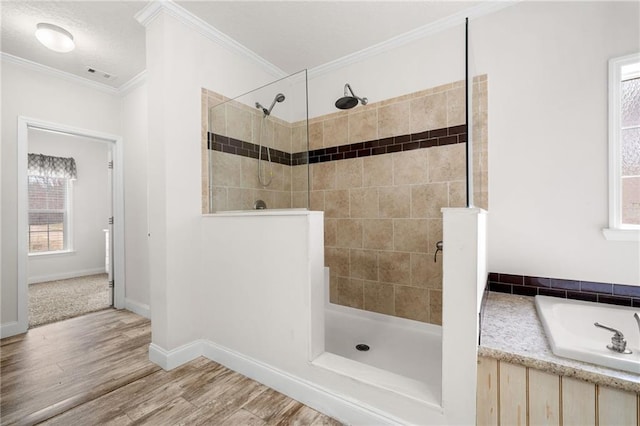 full bathroom featuring wood finished floors, baseboards, visible vents, ornamental molding, and a walk in shower