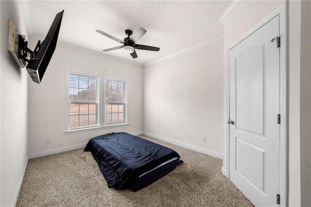 carpeted bedroom featuring crown molding, baseboards, and a textured ceiling