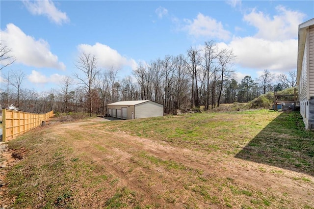 view of yard with an outdoor structure, an outbuilding, fence, and a detached garage