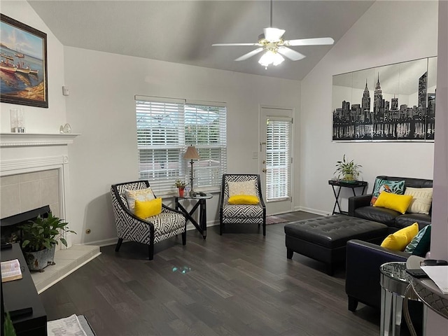 living area featuring lofted ceiling, dark wood-type flooring, ceiling fan, and a fireplace