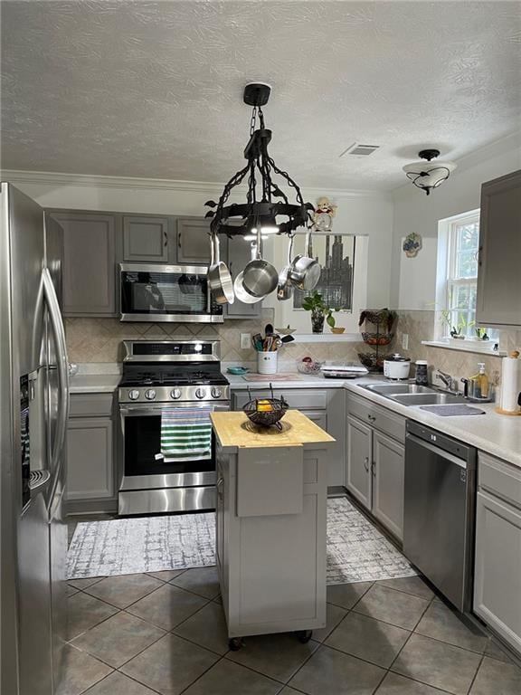 kitchen featuring a center island, backsplash, sink, and appliances with stainless steel finishes