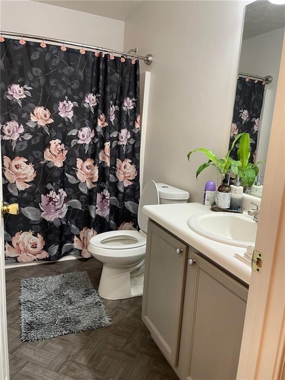 bathroom featuring vanity, toilet, curtained shower, and parquet floors