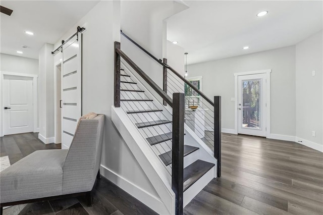 stairs featuring wood-type flooring and a barn door