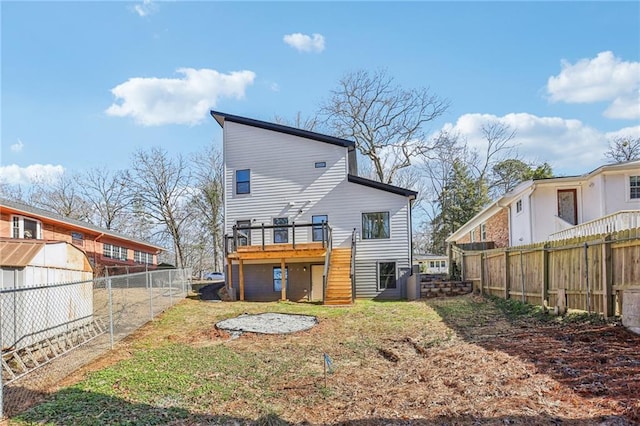 back of property featuring a deck and a lawn