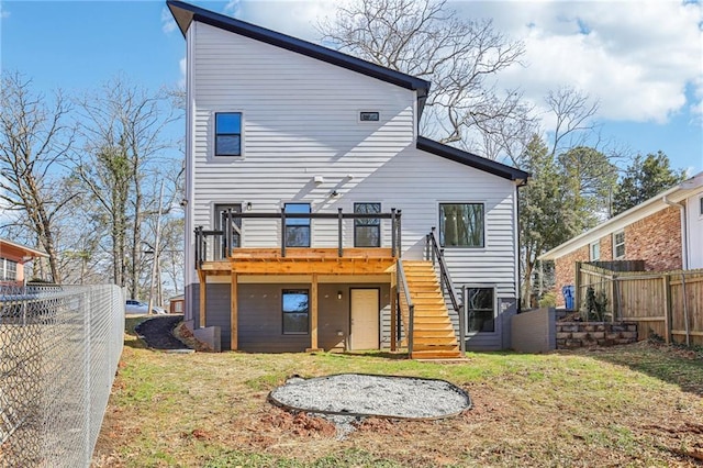 back of house featuring a wooden deck and a lawn