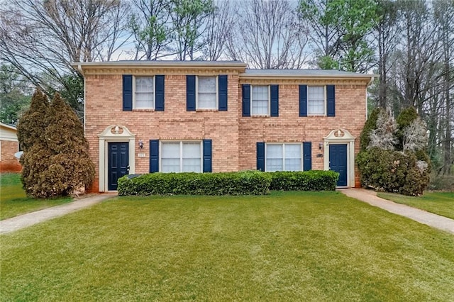 colonial house featuring brick siding and a front lawn