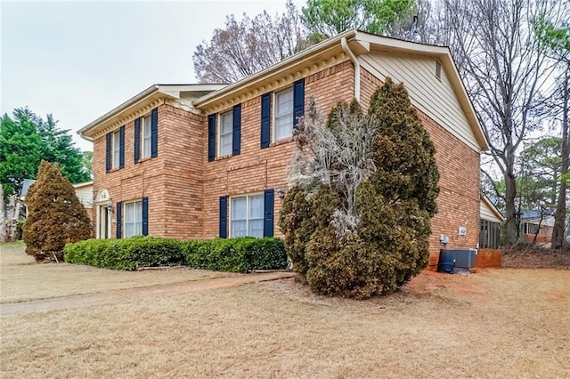 view of property exterior with brick siding, a lawn, and cooling unit