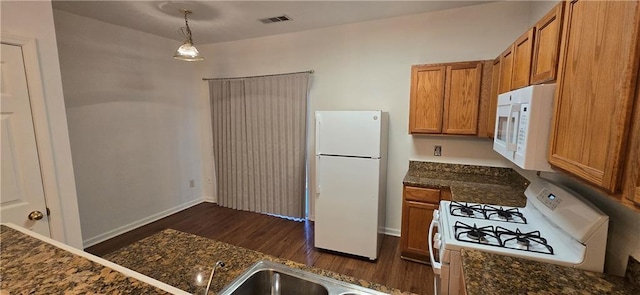 kitchen featuring white appliances, dark wood-style floors, visible vents, a sink, and brown cabinets