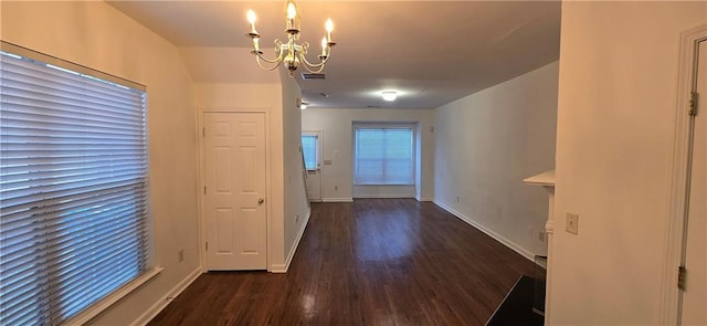 unfurnished dining area with visible vents, baseboards, dark wood-type flooring, and an inviting chandelier