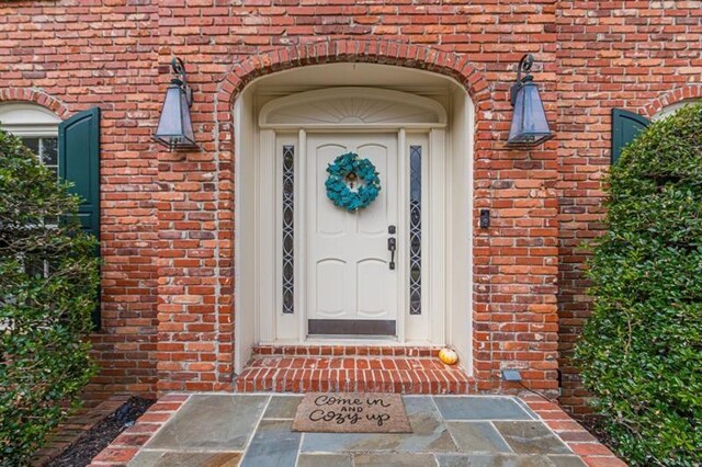 view of exterior entry with brick siding
