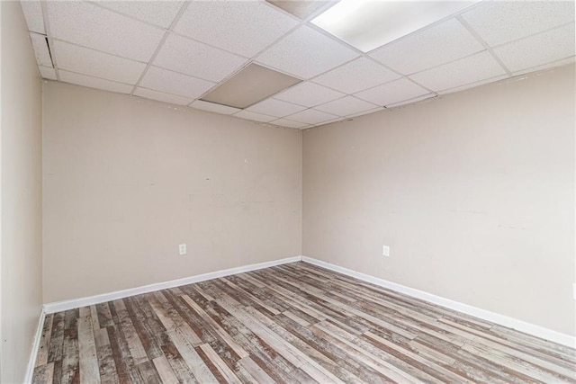 spare room with hardwood / wood-style floors and a drop ceiling