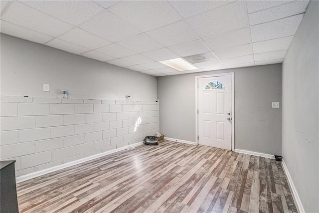 interior space with a paneled ceiling and wood-type flooring