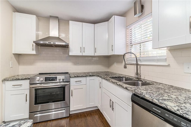 kitchen with white cabinetry, stainless steel appliances, and wall chimney range hood