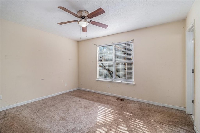 carpeted empty room featuring ceiling fan and a textured ceiling