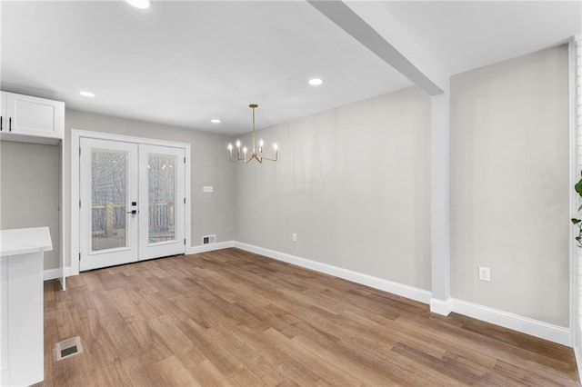 unfurnished dining area featuring light wood-style floors, visible vents, and baseboards